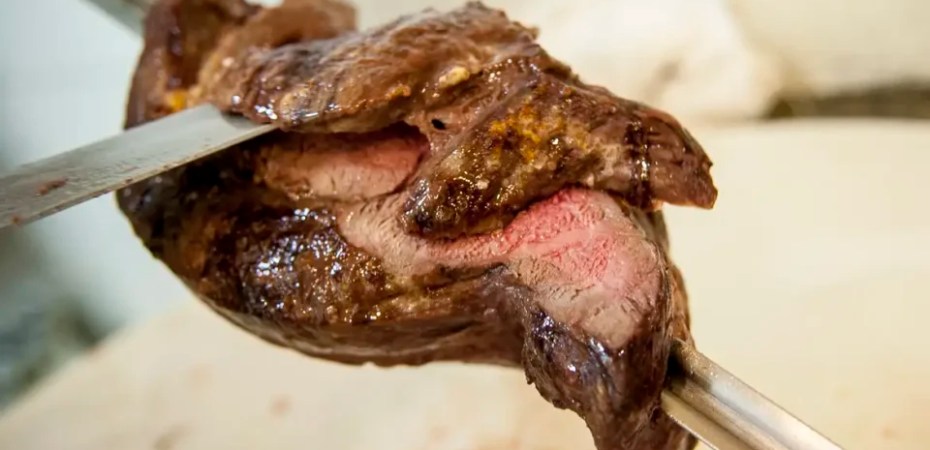 Pedaços de carne grelhada e copos de bebida simbolizam risco aumentado.