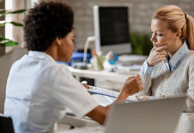 Mulher em ambiente de trabalho, simbolizando equilíbrio entre carreira e tratamento oncológico