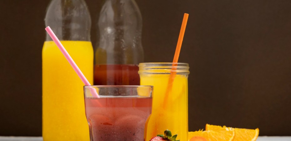 Copos de refrigerante e suco adoçado, representando o consumo diário que eleva o risco hepático.